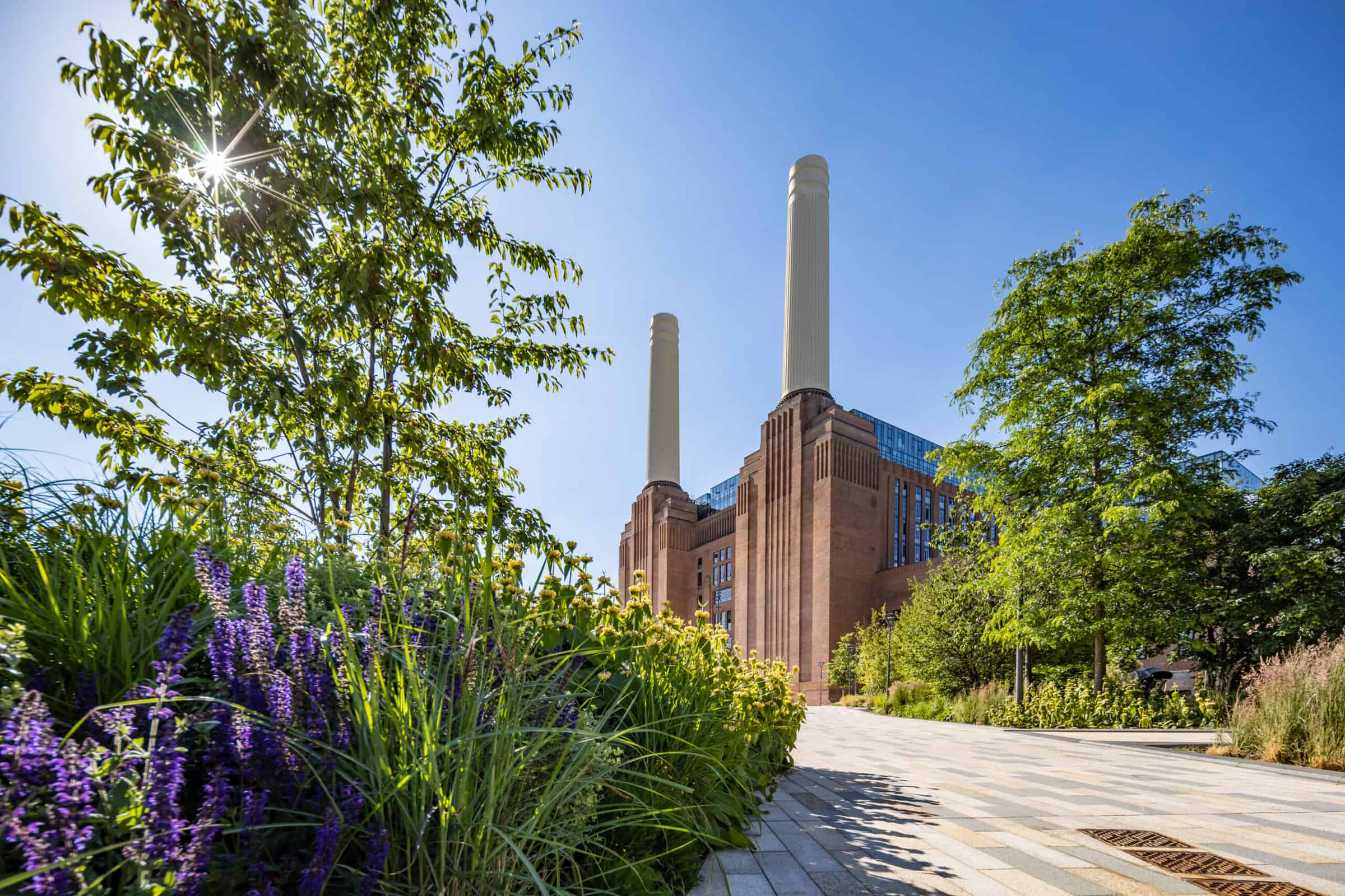 Yeşil kamusal alanın arkasında yükselen Battersea Power Station